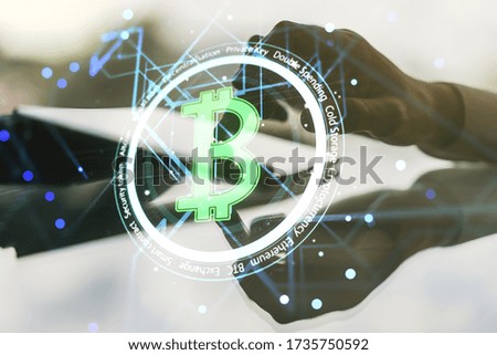 Creative Bitcoin concept with finger presses on a digital tablet on background. Double exposure