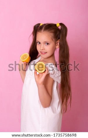 Young attractive girl posing at studio with lemon. Vitamin C
Portrait of pretty little girl holding slices of orange