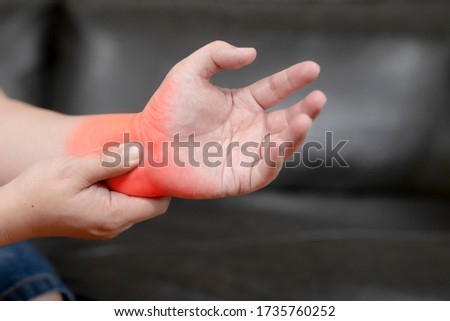A young man with pain in his hand because of hard work, Ache in human body , office syndrome,Bone and joint disease, Concept healthcare and medical.