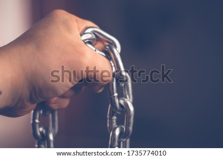 Metal chain in male hand with blurry background