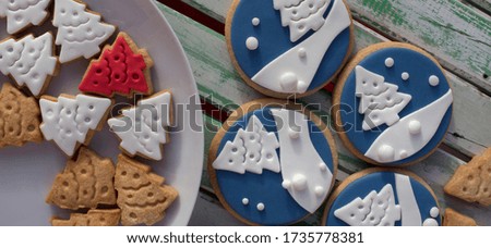 round christmas themed cookies. Trees silhouette on blue background.