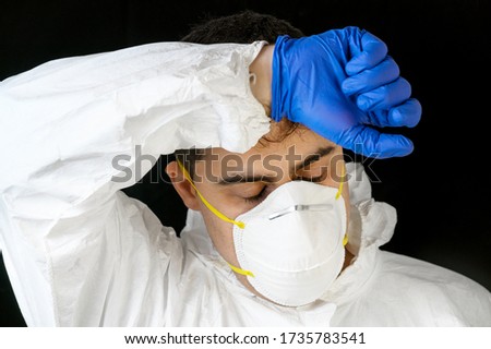 COVID-19. Exhausted Doctor, in personal protective equipment, worried as the coronavirus infected cases and death tolls rises. Emotional stress of health workers .