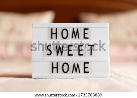 Lightbox with text: home sweet home on bed, copy space.
