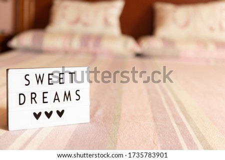 Lightbox with text: sweet dreams, on the bed, copy space.