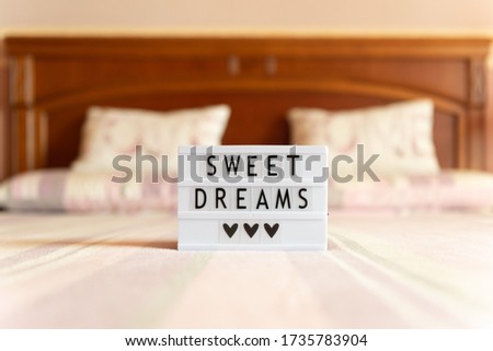 Lightbox with text: sweet dreams, on the bed, copy space.