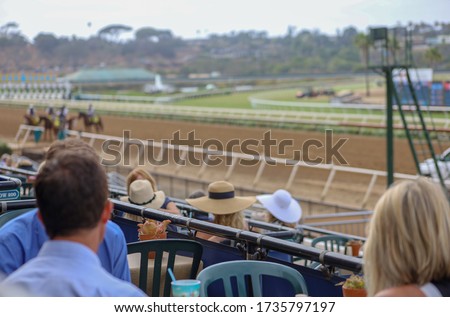 Blurred people at the racetrack background.