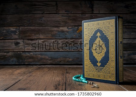 Islamic concept - The Holy Al Quran with written Arabic calligraphy meaning of Al Quran and rosary beads or tasbih,Arabic word translation : The Holy Al Quran (holy book of Muslim) 