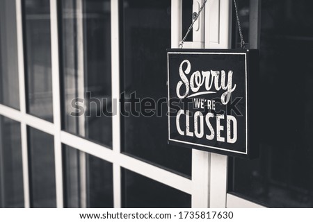 Sorry we're closed sign. grunge image hanging on cafe glass door.