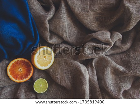 Orange yellow lemon green lime and spice herbs on brown rustic raw sackcloth fabric photo. A4 A5 international paper slide poster card corner element with free blank copy space for text