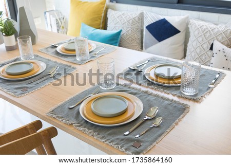 Table set on dinning table with yellow and grey plate setting. Royalty-Free Stock Photo #1735864160
