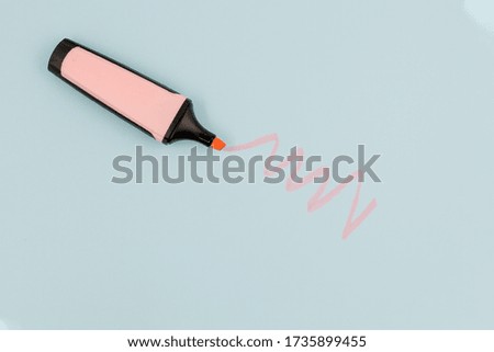 Pink highlighter draws doodle on a blue paper background with copy space