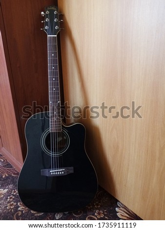 Black guitar with white strings