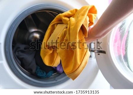Woman's hand Pick up clothes Washing machine.Clean and Healthy Concepts.