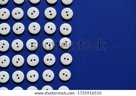 Pattern white wooden buttons on a blue background with a copier space