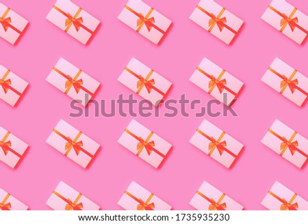Green Christmas gift box on pink color background flat lay, top view pattern