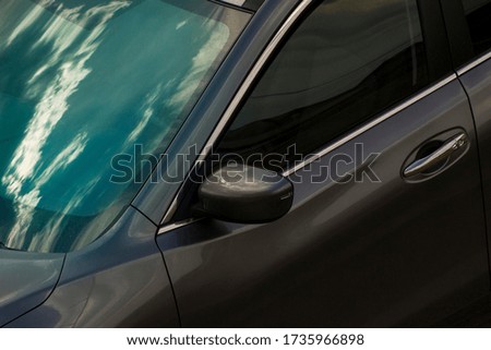 Detail of modern car, sky reflection on windshield