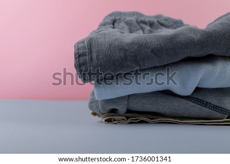 children's clothing after washing machine. iron clothes folded in a pile of clothing & soft pink background color