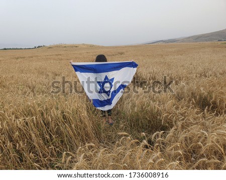 child with israel flag in field