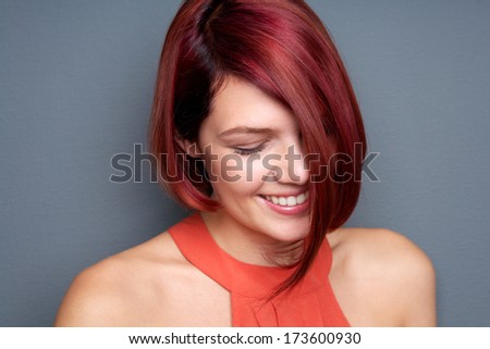 Close up portrait of a smiling woman with eyes closed against gray background