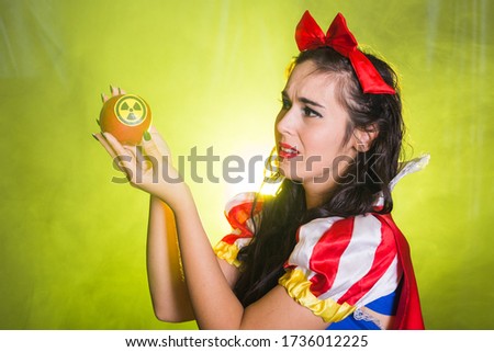 Woman holding hazardous radioactive apple. Nuclear and radiation measurement concept.