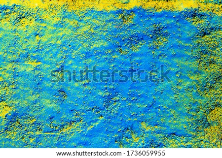 Fragment of colorful graffiti painted on a concrete wall. Bright yellow and blue abstract background for design.