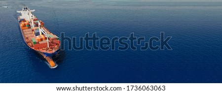 Aerial drone panoramic ultra wide photo of industrial container tanker ship cruising in open ocean deep blue sea