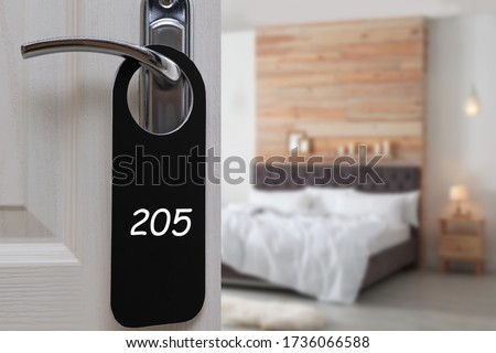 Open door with sign 205 on handle in hotel, closeup. Space for text