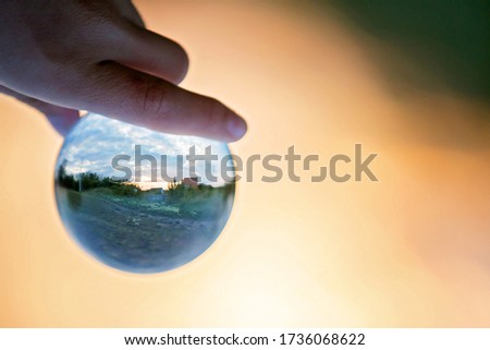 Little child, boy holding poppy on sunset picture taken through a glass ball