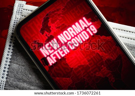 The New Normal After Covid-19 background concept. A smartphone with new normal after covid19 message with world map on the medical face mask on grunge red earthmap. Royalty-Free Stock Photo #1736072261