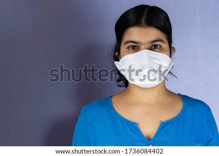 head shot of an Indian woman wearing N-95 nose mask and looking at camera for corona virus or covid-19 protection Royalty-Free Stock Photo #1736084402