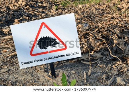 Translation: "Attention. Leaves left for the hedgehog" sign in the park. Closeup