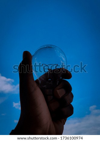 bulb in the hand with background of blue sky 