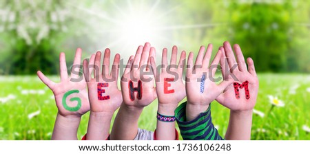Children Hands Building Word Geheim Means Secret, Grass Meadow