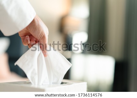 women hand picking napkin/tissue paper from the tissue box Royalty-Free Stock Photo #1736114576