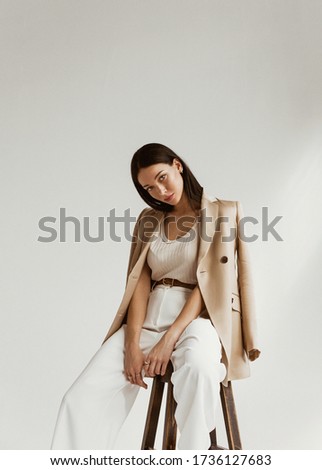 girl in a beige jacket fashion on a white background Royalty-Free Stock Photo #1736127683