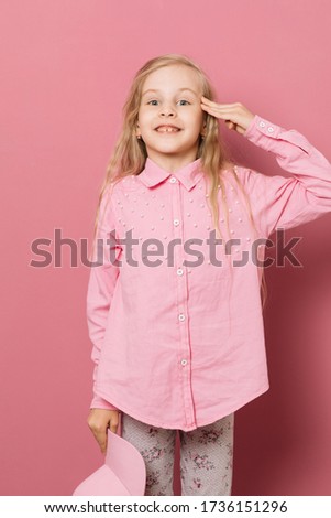 Little girl in pink clothes and a medical mask on a pink background