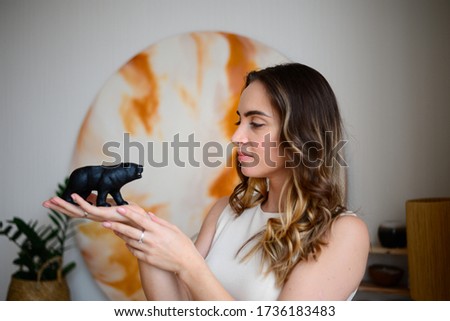 Figurine black bear in the hands of a young woman