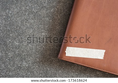 Leather cover note with tag on texture background.