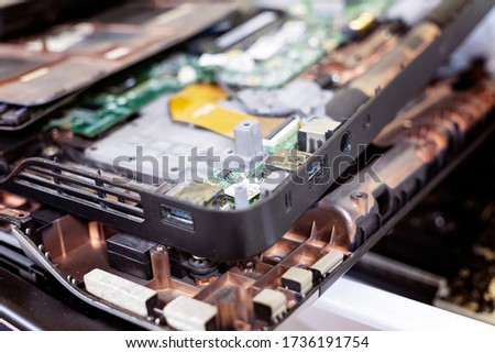 Closeup of disassembled laptop in recycling plant. Concept of electronic waste and management reuse recycle and recovery. Old E-waste device is ready for recycling. Royalty-Free Stock Photo #1736191754