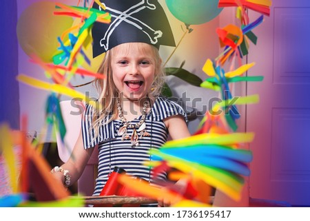 A child in a pirate costume smiles and plays. Bright festive photo of a pirate party. Baby's birthday. Adventure and travel at home