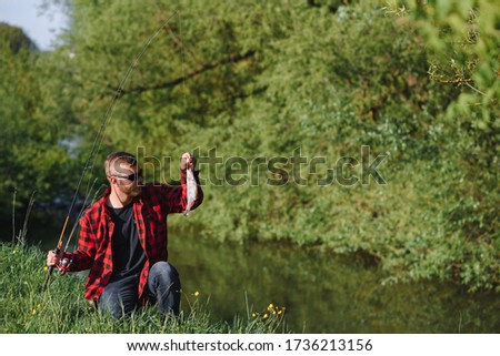 young fisherman fishes near the river. The concept of outdoor activities and fishing