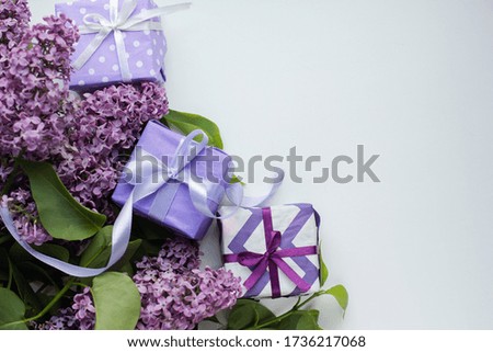 colorful modern gift boxes with lilac on white background. presents with flowers