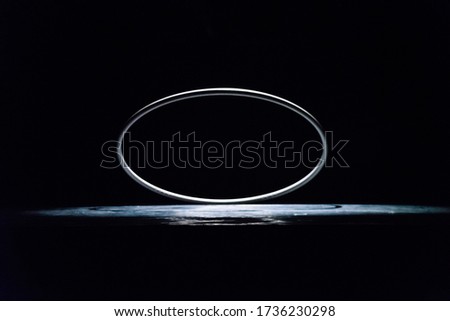 a metal ring in spot of light on the dark background