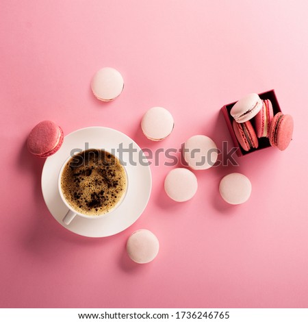 Morning cup of coffee, cake macaroons, gift or present box on pink background from above. Beautiful breakfast. Flat lay style.