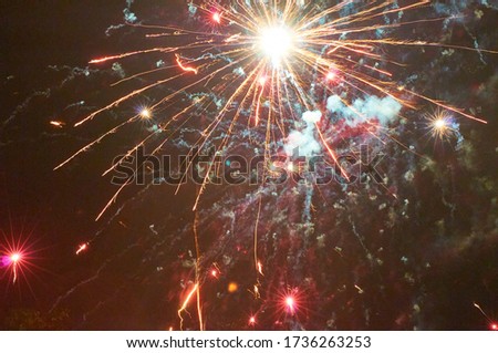 Colourful fireworks on the black sky background. Holiday art background. Long exposure and photo noise