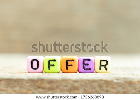 Colorful bead with black letter in word offer on wood background