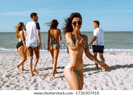 Group of friends  having fun and running along  beach. Young friends  enjoying on beach holiday. Summer, relax and lifestyle concept.