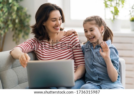Happy loving family. Young mother and daughter girl using laptop. Funny mom and lovely child are having fun staying at home.
