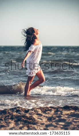 Young woman in a white dress on the beach 