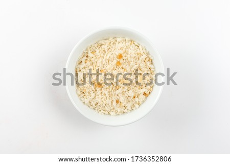 Heap of Bread Crumbs in white ceramic bowl. Top View. Crushed Rusk Bread Crumbs or Panko Isolated. Royalty-Free Stock Photo #1736352806